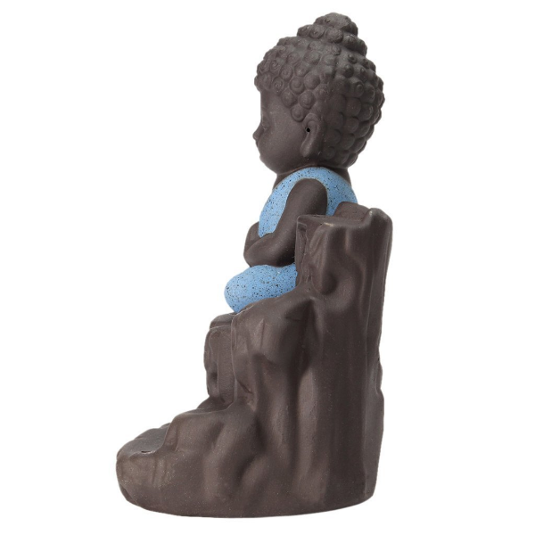 Backflow Incense Holder displaying meditating monk Buddha beside sculpted waterfall feature indoors